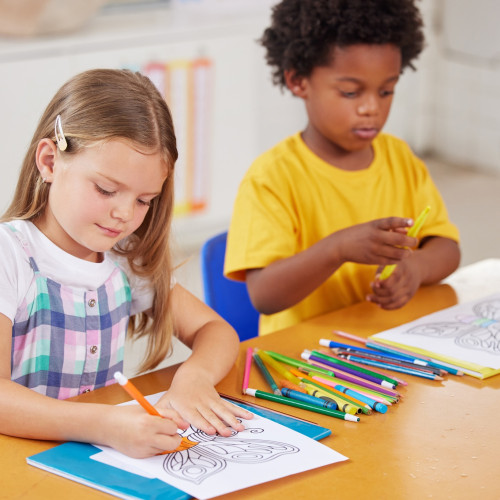 Colouring is a great sitting still activity. Shot of preschool students colouring in class.